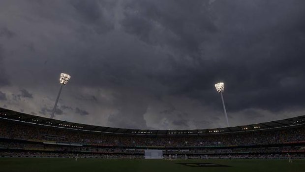 Storm clouds gather above the light towers during the fourth day's play at the Gabba.