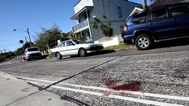 Blood stains the road outside the Marrickville house where a man was stabbed last night.
