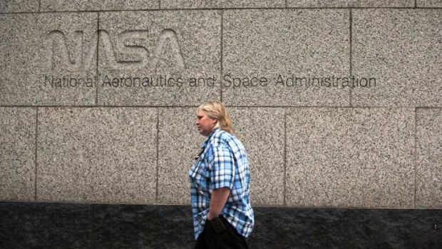 A woman walks past the NASA headquarters on Tuesday morning after the federal government shutdown. NASA turns 55 today, but the organisation had to send home the majority of its staff without pay.