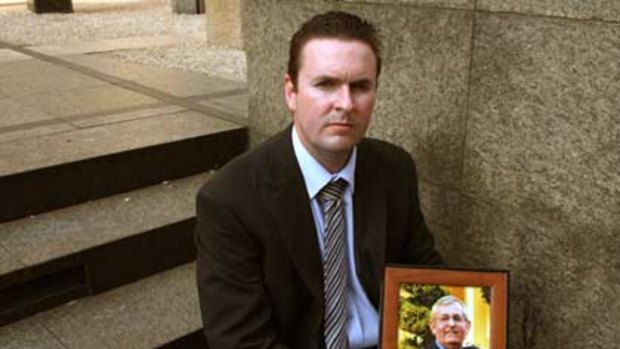 Bashed to death...Nigel Smith holding a photograph of his father Wayne.