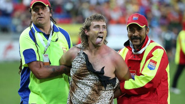 A spectator dressed as Tarzan is ejected from the stadium after getting onto the outer field during the parade of nations at Westpac Stadium.
