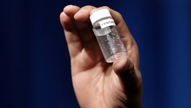 A reporter holds up an example of the amount of fentanyl that can be deadly after a news conference in Virginia, US.