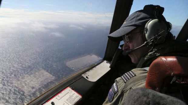 Royal New Zealand Air Force P-3 Orion's captain, Wing Commander Rob Shearer watches out of the window of his aircraft while searching for the missing Malaysia Airlines Flight MH370 in the southern Indian Ocean.