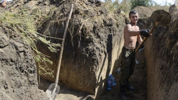 Digging deep: A Ukrainian soldier digs a trench on the outskirts of Mariupol.