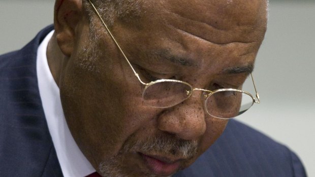 Former Liberian President Charles Taylor takes notes during his trial in 2012 at an international court in The Hague. 