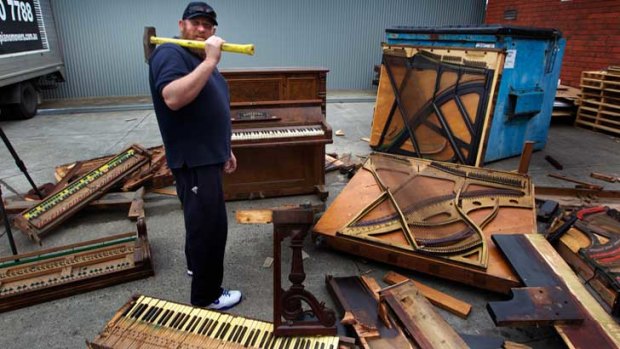 Paul McDonald destroys old pianos with a sledgehammer.