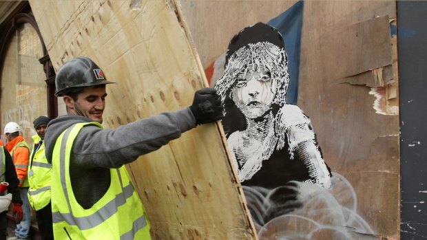 The new Banksy artwork opposite the French embassy in London is covered. The work criticises the use of tear gas in the refugee camp in Calais. 