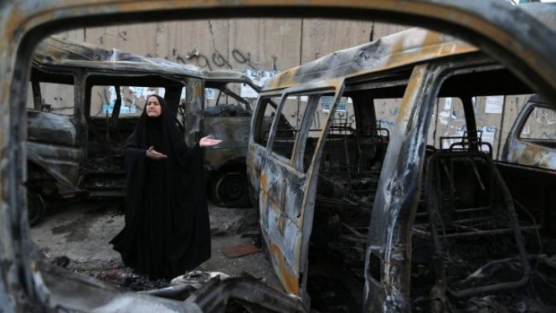 A woman reacts to the carnage at the site of a car bomb attack in the Shula neighborhood of Baghdad.