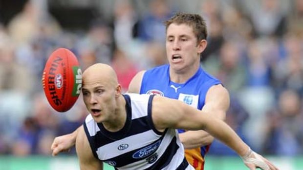 Cats wizard Gary Ablett, with Brisbane's James Polkinghorne in tow, loses sight of the ball.