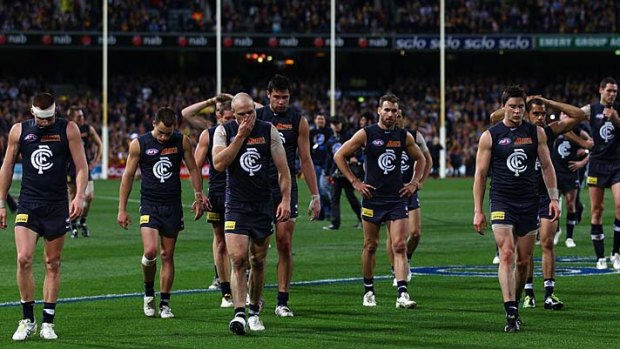 Picture of despair: Carlton players trudge off the field after their narrow loss to the Eagles last night.