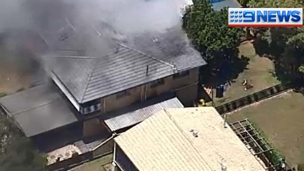 Smoke billows from a home in Jindalee.