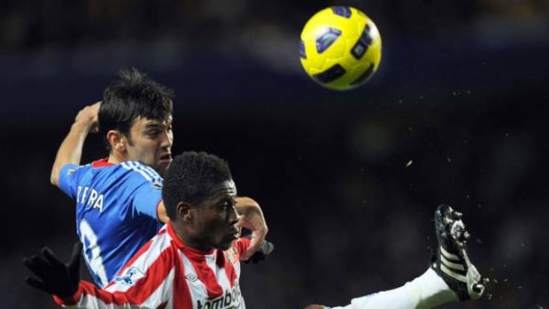 Chelsea's Paulo Ferreira (left) battles for the ball with Asamoah Gyan at Stamford Bridge.