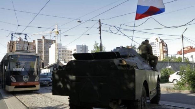 A pro-Russian fighters' armoured vehicle travels near the captured Interior Ministry headquarters in Donetsk, eastern Ukraine.