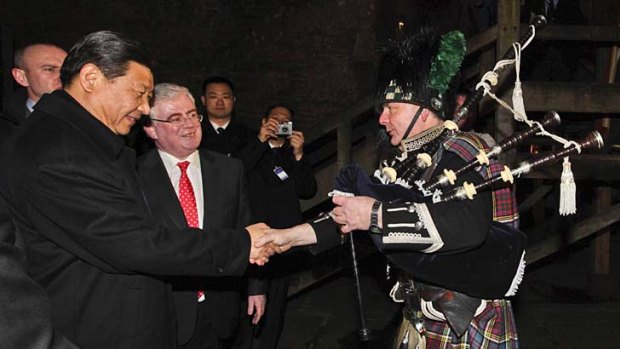 China's Vice President Xi Jinping (left) and Ireland's Deputy Prime Minister Eamon Gilmore meet bagpiper Neil Carey.