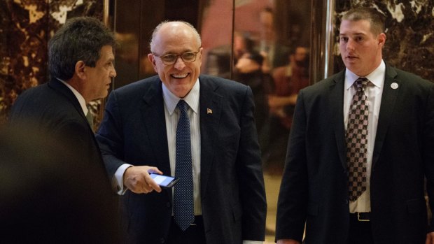 Former New York Mayor Rudy Giuliani, center, smiles as he leaves Trump Tower on Friday.