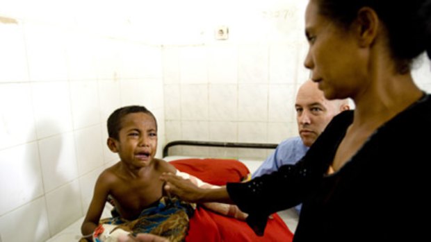 Andian Lannga cries after a skin graft at a makeshift Indonesian clinic.