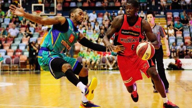 Perth Wildcats forward James Ennis drives to the basket past Townsville's Joshua Pace during the round 13 NBL match between the Townsville Crocodiles and the Perth Wildcats at Townsville Entertainment Centre.