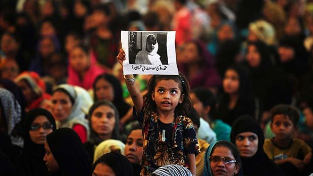 A child holds aloft a photo of Malala Yousafzai during a protest in Karachi over her shooting by the Taliban.