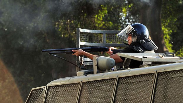 An Egyptian riot policeman readies to fire rubber bullets towards supporters of deposed Egyptian President Mohamed Mursi during clashes that erupted with pro-government supporters in Tahrir Square and around the US Embassy in Cairo.