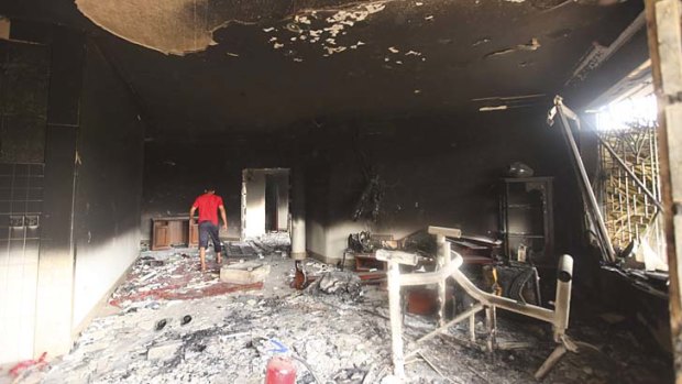 A man walks inside the US consulate, which was attacked and set on fire by gunmen in Benghazi, killing four people.