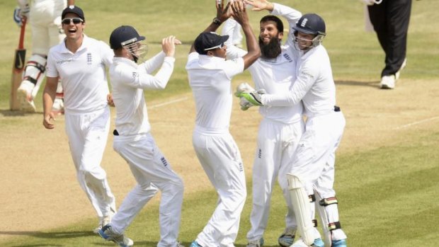 Moeen Ali celebrates with his teammates after dismissing India's Bhuvneshwar Kumar.