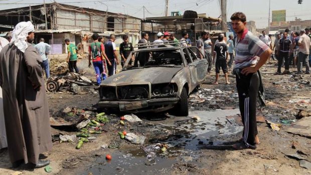 People gather at the site of a car bomb attack in the Iraqi capital of Baghdad.