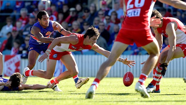 Squaring up: Bulldogs and Swans players battle for the ball in yesterday’s clash in Canberra. Sydney’s eight-point win left the Bulldogs floundering with three consecutive losses.