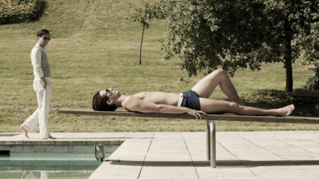 Admiring glance: Pierre Niney's Yves Saint Laurent reclines as Pierre Berge (Guillaume Gallienne) strolls poolside.