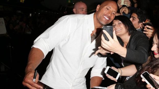 Dwayne Johnson signs autographs and poses with fans at the screening of <i>Hercules</i> in Sydney.