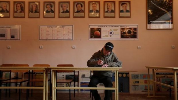 Ivan Kozlov registers to vote at a polling station at a school in Sevastopol.