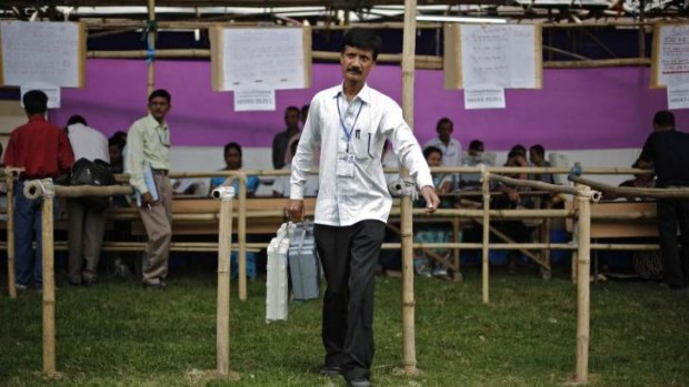 A polling officer carries an electronic voting machine in the Indian state of Assam.