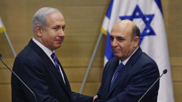Political lifeline ... Israel's Prime Minister Benjamin Netanyahu, left, and Kadima party leader, Shaul Mofaz, shake hands before holding a joint press conference announcing the new coalition government in Jerusalem.