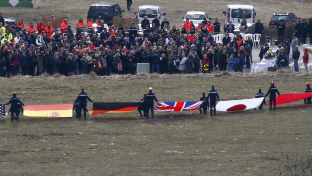 Flags representing some of the nationalities of the victims are seen as family members and relatives gather near the crash site of an Airbus A320 in the French Alps.