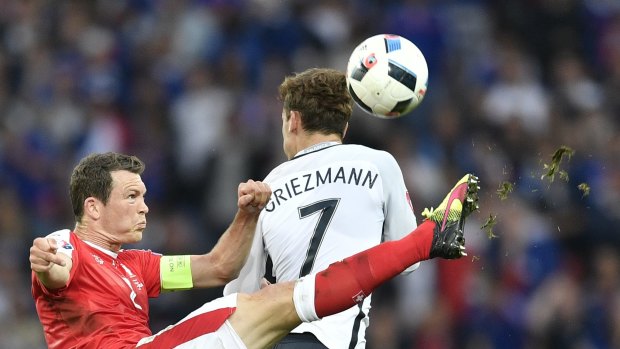 Switzerland's Stephan Lichtsteiner, left, finds the ball against France's Antoine Griezmann.