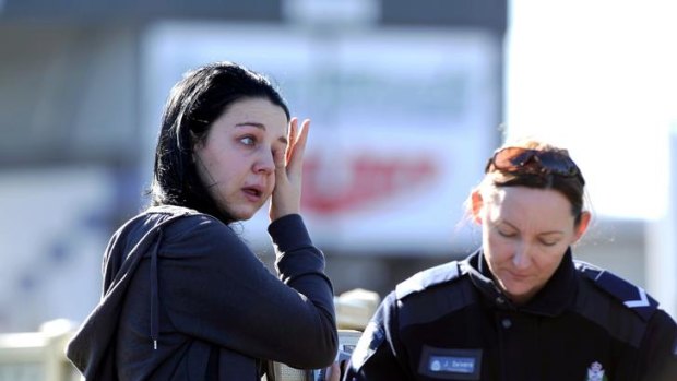 A distraught woman speaks to police after arriving at the scene of the Keilor East siege.