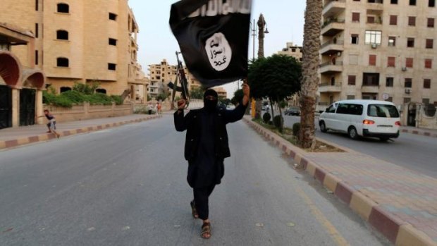 A member loyal to the Islamic State waves an ISIL flag in Raqqa.