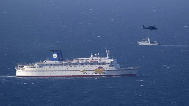Military alert: an Israeli  naval ship and an air force helicopter operate next to a cruise ship off the coast of Haifa on Thursday.