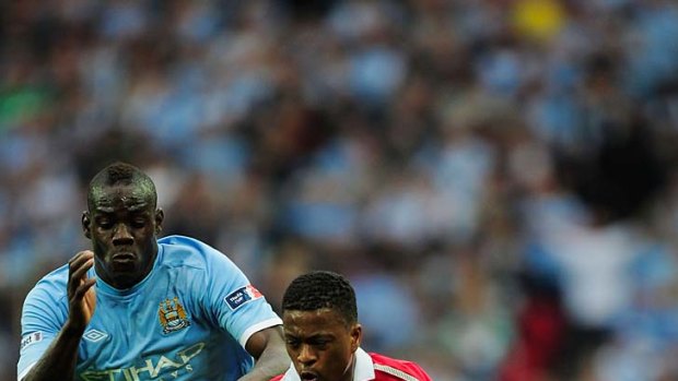 Mario Balotelli of Manchester City chases Patrice Evra of Manchester United.