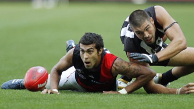 Essendon defender Courteney Dempsey and his opponent, Magpie forward Chris Dawes, eye off the footy.