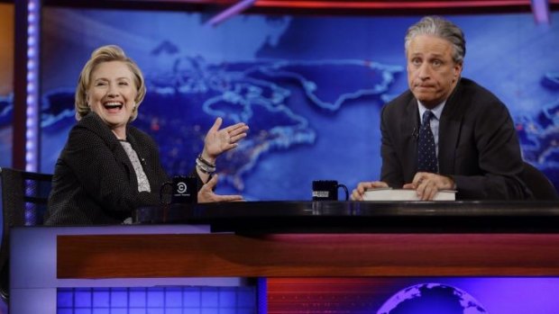 Former U.S. Secretary of State Hillary Rodham Clinton reacts to host Jon Stewart during a taping of The Daily Show with Jon Stewart in New York.