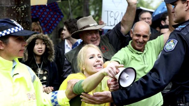 People from The Socialist Alternative and the Justice for Palestine groups are met by anti-protestors including Logan City Councillor Hajnal Ban (yellow raincoat) at a protest at the Max Brenner store at South Bank on Saturday.