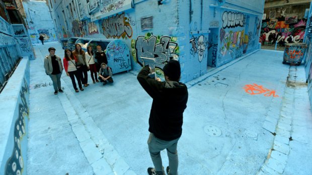 Passers-by drink in Rutledge Lane, which was painted blue overnight.