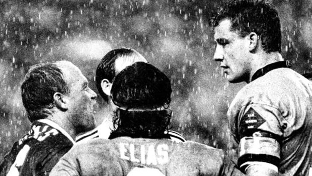 The power and the passion ... Wally Lewis and Mark Geyer go head to head during the 1991 series as Blues hooker Benny Elias looks on.