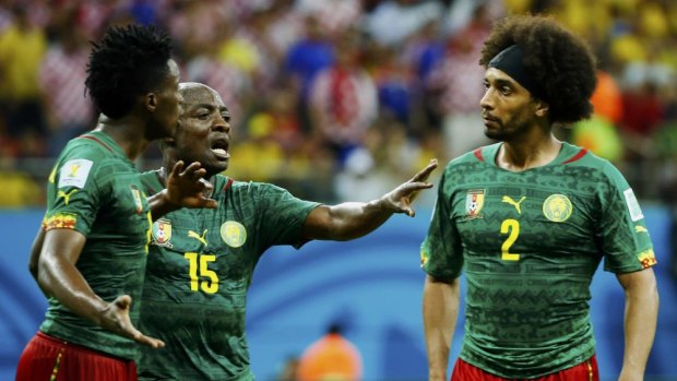 Furious row: Cameroon's Achille Weboc tries to separate teammates Benjamin Moukandjo and Benoit Assou-Ekotto.