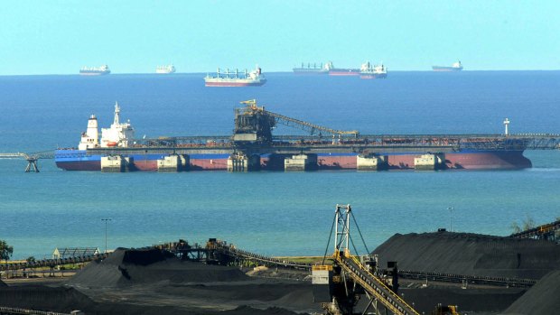 A ship is loaded with coal from the stockpiles at the Hay Point terminal as others wait offshore to be loaded at the Dalrymple Bay international coal export terminal south of Mackay. 