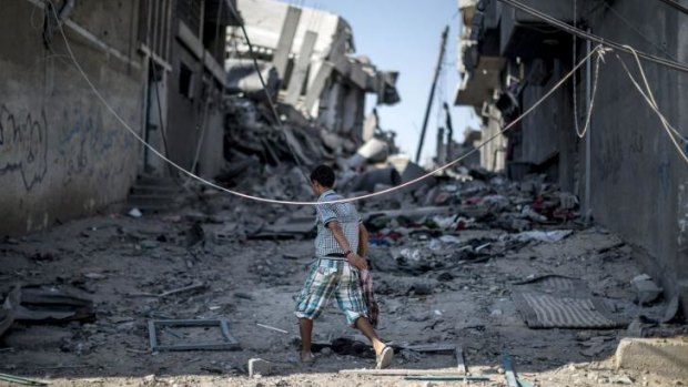 A Palestinian boy walks amid the rubble of destroyed buildings in Shujaiya, Gaza.