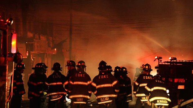 Fiery blaze ... New York City firefighters try to bring growing flames under control on Rockaway Beach Boulevard in Queens.