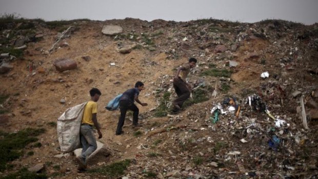 Child labour: Young Indian ragpickers ascend a hillock while searching for reusable garbage at a dumping ground on the outskirts of New Delhi, India