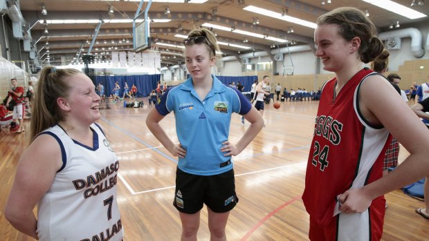 Damascus player Darcie Murphy chats with Canberra Capitals player Abbey Wehrung and Girls Grammar player Rosemary Schweizer.