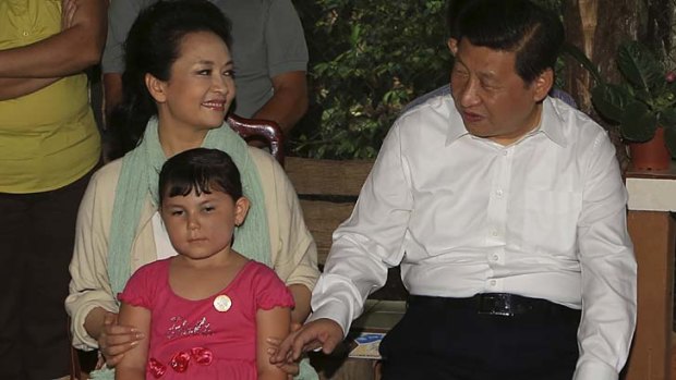 Wooing their hosts: China's President Xi Jinping and his wife Peng Liyuan sit next to a child during their visit to a family at a coffee farm in Costa Rica.